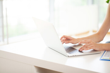 Close up woman sitting at desk and working at computer hands
