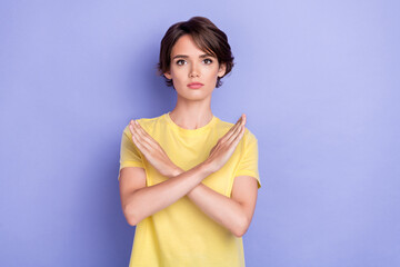 Photo of young adorable gorgeous nice woman serious wear yellow t-shirt crossed hands no stop symbol isolated on purple color background
