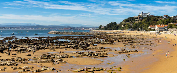Panoramic view of Spanish coastline in the city of Santander with low tide sea and rocky beach in summer