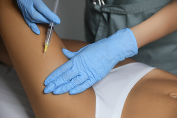 Fototapeta na wymiar Young woman getting legs injection in salon, closeup