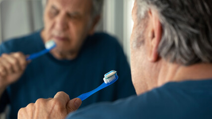 Old man brushing his teeth	