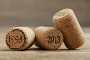 Wine corks with different dates on wooden table, closeup