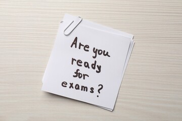 Note with question Are You Ready For Exams? on white wooden table, top view