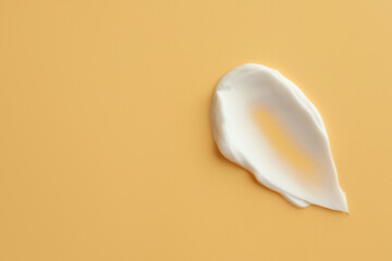 Sample of face cream on yellow background, top view. Space for text