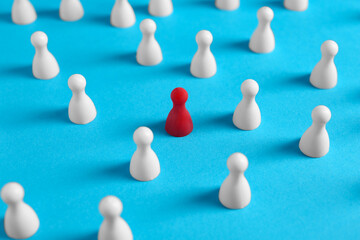 One red pawn among others on light blue background. Social inclusion concept