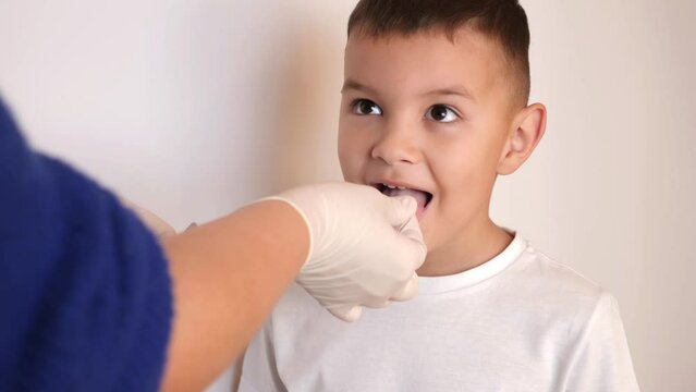 A little boy is given a throat lozenge.