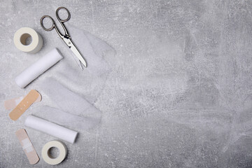 White bandage rolls and medical supplies on light grey table, flat lay. Space for text