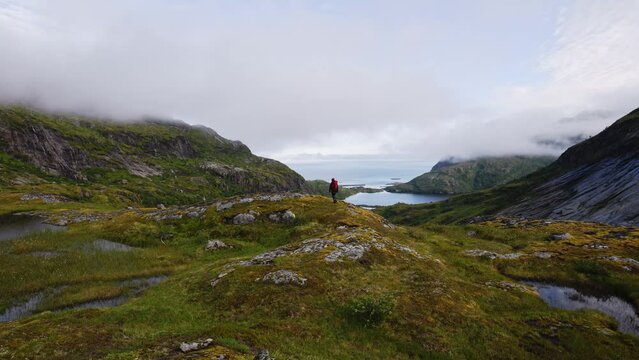 Tourist with a backpack on top and looking at the Landscape on the way to the top of Manken mountain.