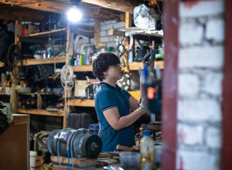 The teenager works in the garage and workshop in the evening.