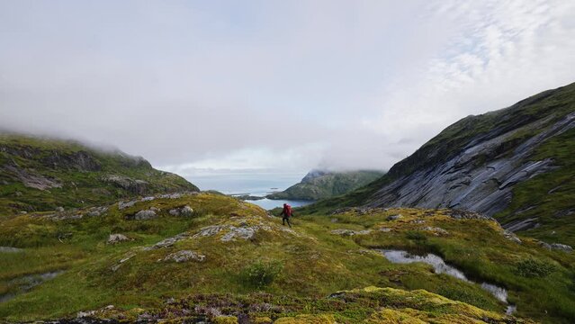 Tourist with a backpack on top and looking at the Landscape on the way to the top of Manken mountain.