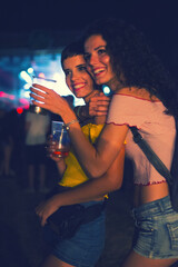 Plakat Two happy young girls dancing and drinking beer on the party concert in the night club 