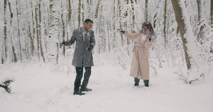 Multiracial couple having fun in a winter forest