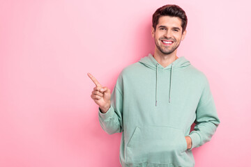 Photo of young funny confident guy student wear stylish khaki hoodie trendy choice finger directing empty space demonstrate product isolated on pink color background