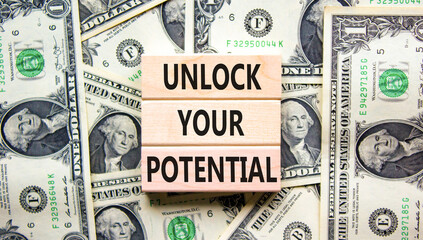 Unlock your potential symbol. Concept words Unlock your potential on wooden blocks. Dollars. Beautiful background from dollar bills. Business, psychological unlock your potential concept. Copy space.