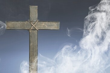 Christian wooden cross with white smoke