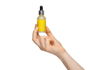 A bottle of vitamin C serum with condensation in a woman's hand.