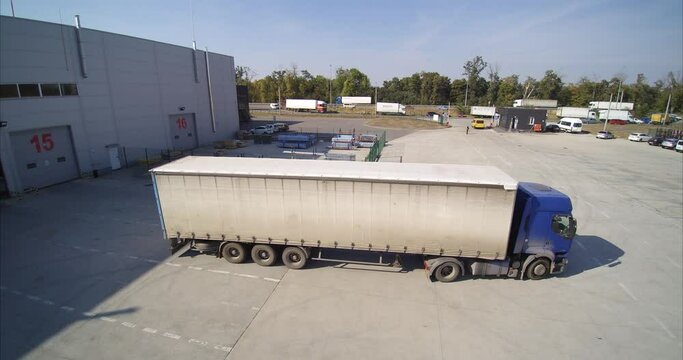 White truck leaves the warehouse after being loaded with goods. Logistics warehouse truck goes to customers with goods