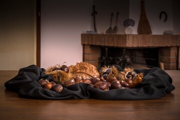Still life of chestnuts on table with fireplace in the background