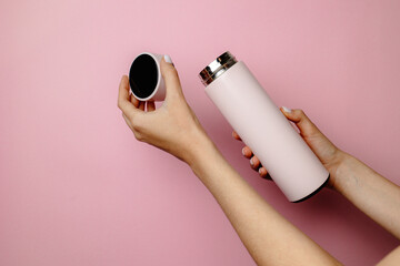 a woman is holding a pink thermos