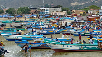 Fototapeta na wymiar Fishing fleet on the beach in the harbor in Puerto Lopez, Ecuador