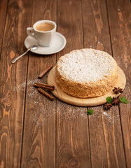 Classic napoleon cake on a wooden table. Homemade cake with a cup of coffee. Selective focus