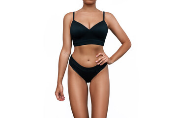 Cropped shot of young tanned woman in black underwear demonstrating her slender figure with toned...