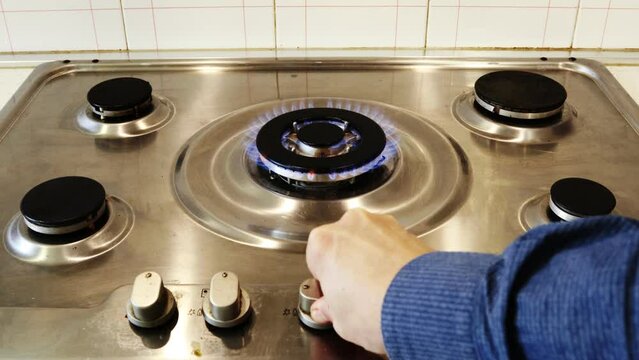 Gas cooker with burning flames of gas. Domestic kitchen with blue flames burning