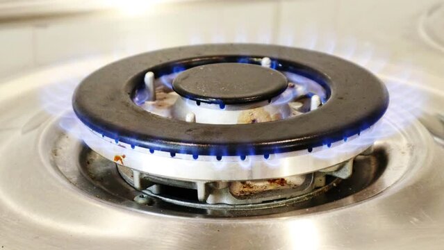 Gas cooker with burning flames of gas. Domestic kitchen with blue flames burning