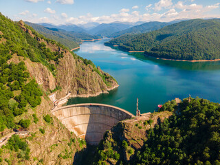 Obraz na płótnie Canvas Aerial photography of Vidraru dam, in Romania. Photography was shot from a drone from above canyon at Vidraru lake with the dam and the lake in the view and mountains in the background.