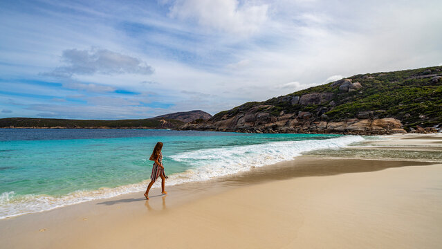 panoramic view of little paradise beach in western australia with a girl in a dress walking, running and fooling around; little hellfire bay in cape le grand national park