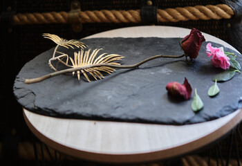 dry rose placed on a stone plate