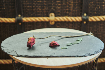 dry rose placed on a stone plate