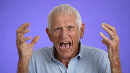 Naklejka premium Closeup of frustrated irritated sad angry elderly gray-haired man 70s in blue shirt yelling scream isolated on plain light purple background studio portrait