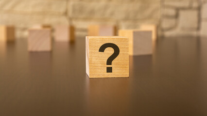 natural wooden cube with question marks, black background