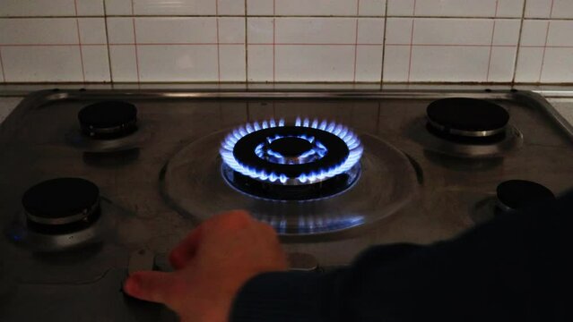 Gas cooker with burning flames of gas. Domestic kitchen with blue flames burning