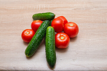 Fresh vegetables on a wooden table. Tomatoes, cucumbers, onions