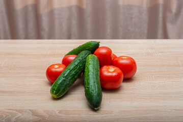 Fresh vegetables on a wooden table. Tomatoes, cucumbers, onions