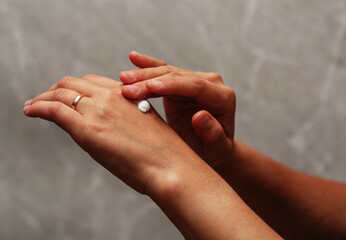 Moisturizing cream on female hands. Focus on fingers.