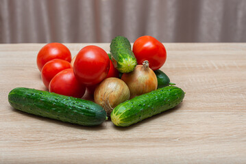 Fresh vegetables on a wooden table. Tomatoes, cucumbers, onions