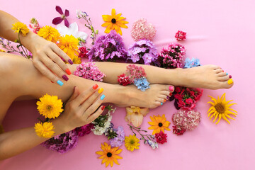 Multicolored manicure and pedicure on square shaped nails with different flowers. - obrazy, fototapety, plakaty