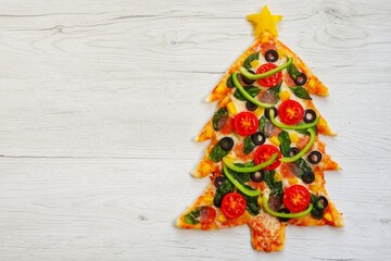 Christmas tree pizza on white wood background.Creative art food idea for celebrate Christmas.Top view.Copy space