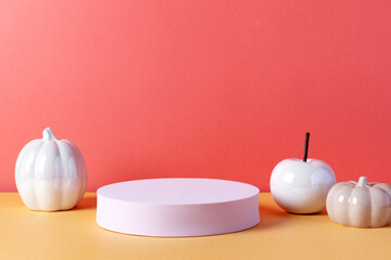 Empty product podium with Halloween pumpkin decor in pastel pink and orange colors