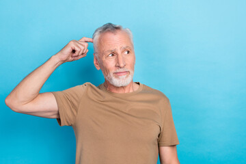 Portrait of thoughtful retired senior with gray hair beard dressed beige t-shirt look empty space...