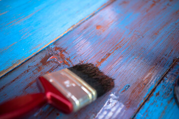 Painting the floor with oil paint. A brush with a colorless varnish covers the wood. Protection of wood from moisture. Paint the old fence.