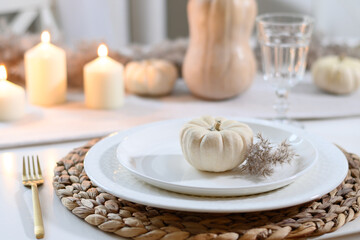 Thanksgiving day table setting with candles, fall decorations, centerpiece of dry flowers and...