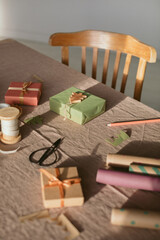 Still life of gift boxes and decorations for wrapping on table. DIY Christmas decoration. Winter holidays, event celebration. Christmas tradition.