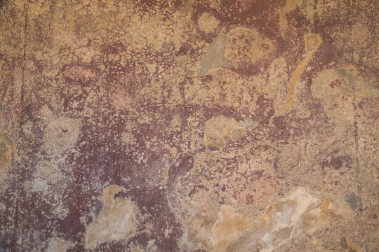Weathered and aged frescos from the ruins of Pompeii in Italy.