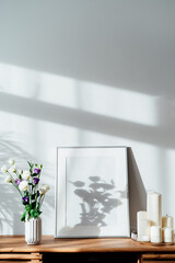 Modern minimalist Scandinavian style interior with white poster mockup, candles and flowers in vase...