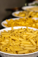 closeup on italian penne pasta on table with various different pasta