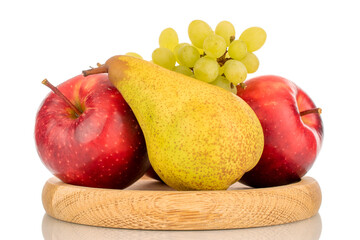 Two red apples, a pear and a grape on a wooden plate, macro, isolated on a white background.